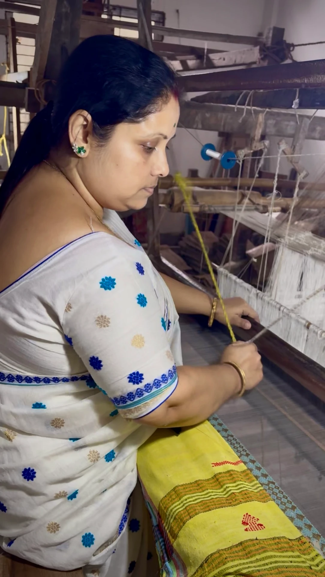 Bhanita Das, a weaver from Sualkuchi, working at her loom