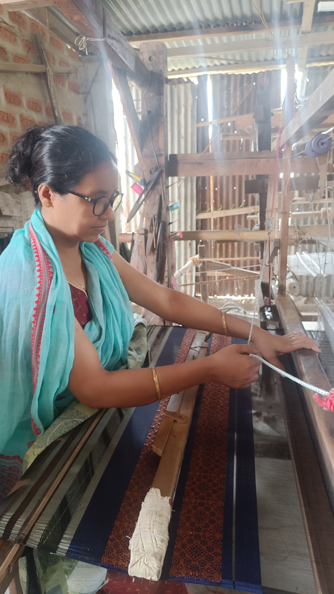 Ranju Das, a weaver from Sualkuchi, working at her loom